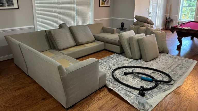 House carpet cleaning near me - sofa cushions removed and arranged for professional upholstery steam cleaning in a home setup.