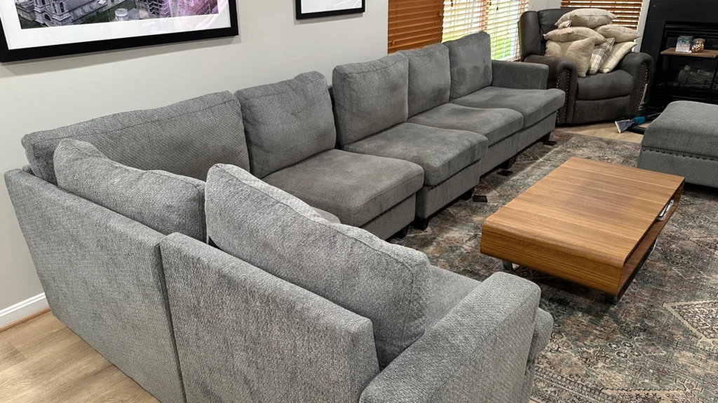 A clean and fresh-looking gray sectional sofa in a cozy living room after a professional carpet and upholstery cleaning service.